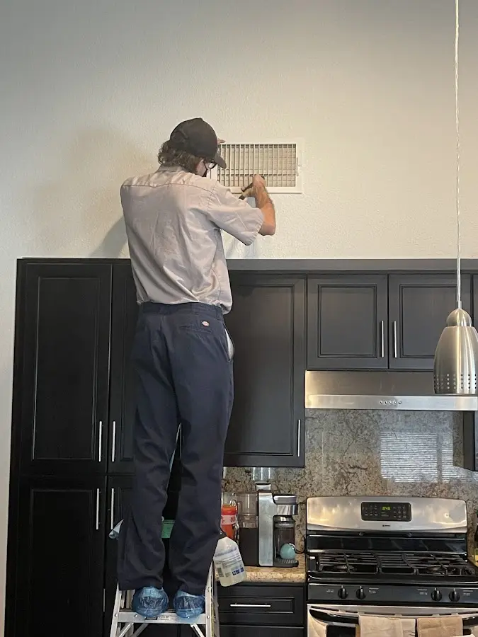 Technician inspecting an air vent during HVAC service in Inverness Highlands South
